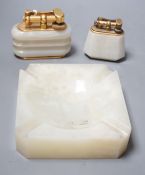 Two Dunhill green onyx table lighters and a matching ashtray, largest lighter 10cms wide