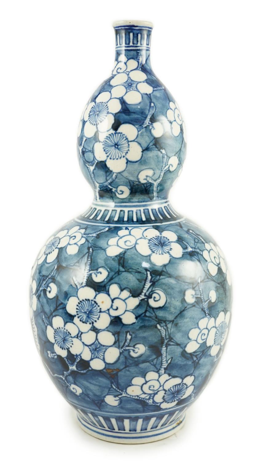 A Japanese blue and white 'prunus' double gourd sake flask, late Edo period, height 32cms 31.5cm