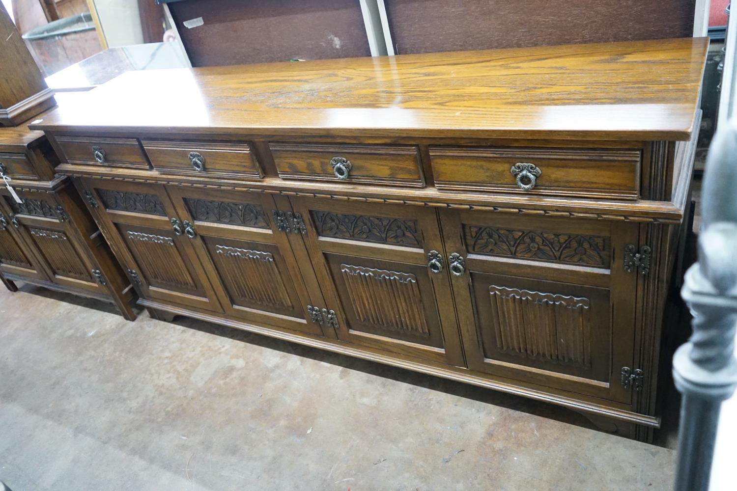 A reproduction 18th century style carved and linen fold moulded oak sideboard width 187cms, depth