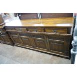 A reproduction 18th century style carved and linen fold moulded oak sideboard width 187cms, depth