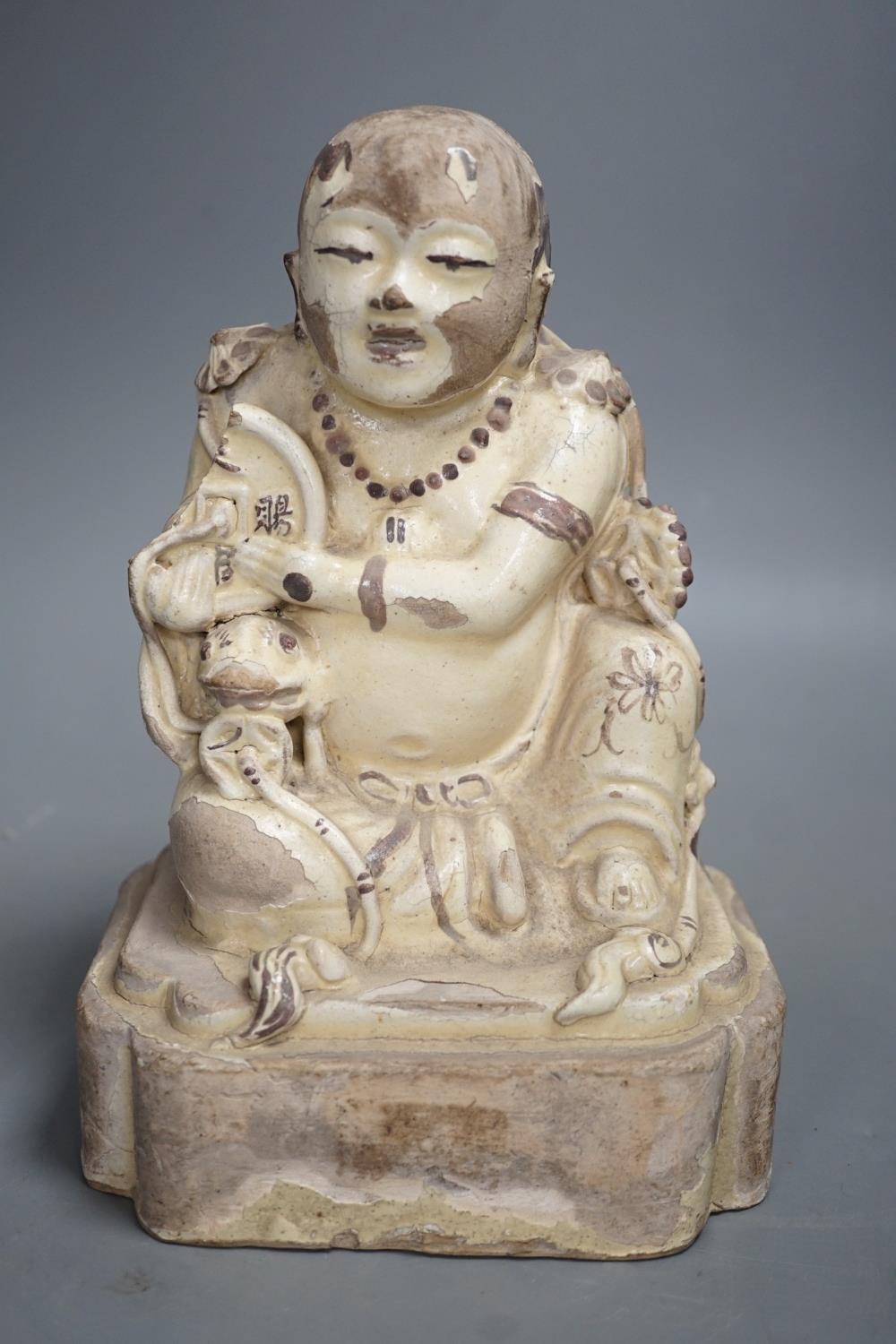 A Chinese Cizhou seated figure of Liu Hai, possibly Ming dynasty, 21cms high, glaze flaking