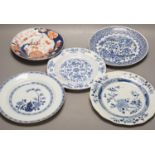 Four Chinese 18th century plates and a late 19th century blue and white dragon plate, largest 24cm