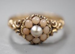 An early 20th century yellow metal, split coral and split pearl cluster set ring, size P, gross