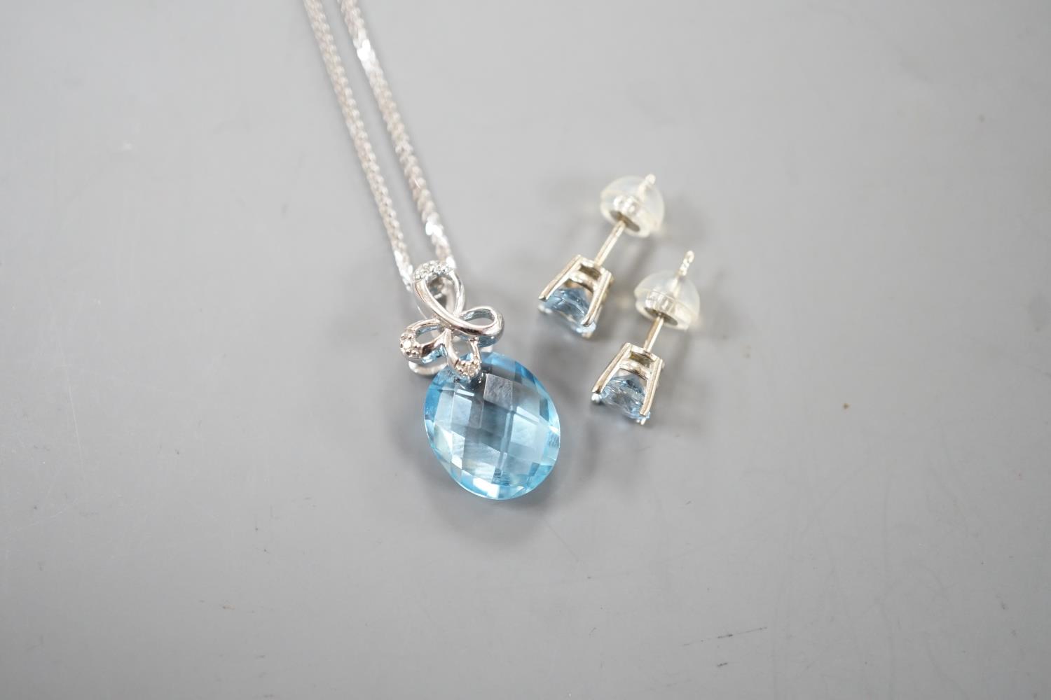 A modern 14k white metal, facetted pear cut blue topaz and diamond chip set pendant, 19mm, on a - Image 3 of 4