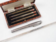An engine-turned silver fountain pen, a cased set of four silver Bridge pencils and a silver