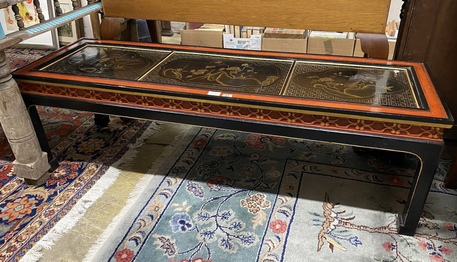 A Chinese black and red lacquered coffee table, the top inset three 18th century lacquer panels,