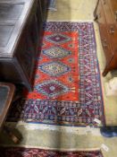 A Caucasian style red ground wool rug, 184cms x 126cms.