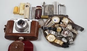 A collection of mixed wristwatches and cigarette lighters and a camera