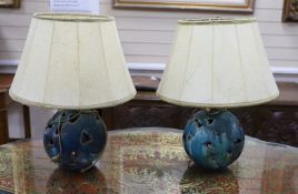 A pair of pierced pottery table lamps with vellum shades
