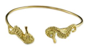 A modern gold and diamond chip set open work bangle, each terminal modelled as a seahorse with