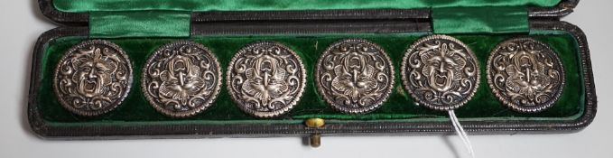 A cased set of six Edwardian silver buttons, each embossed with a mask, Henry Matthews,