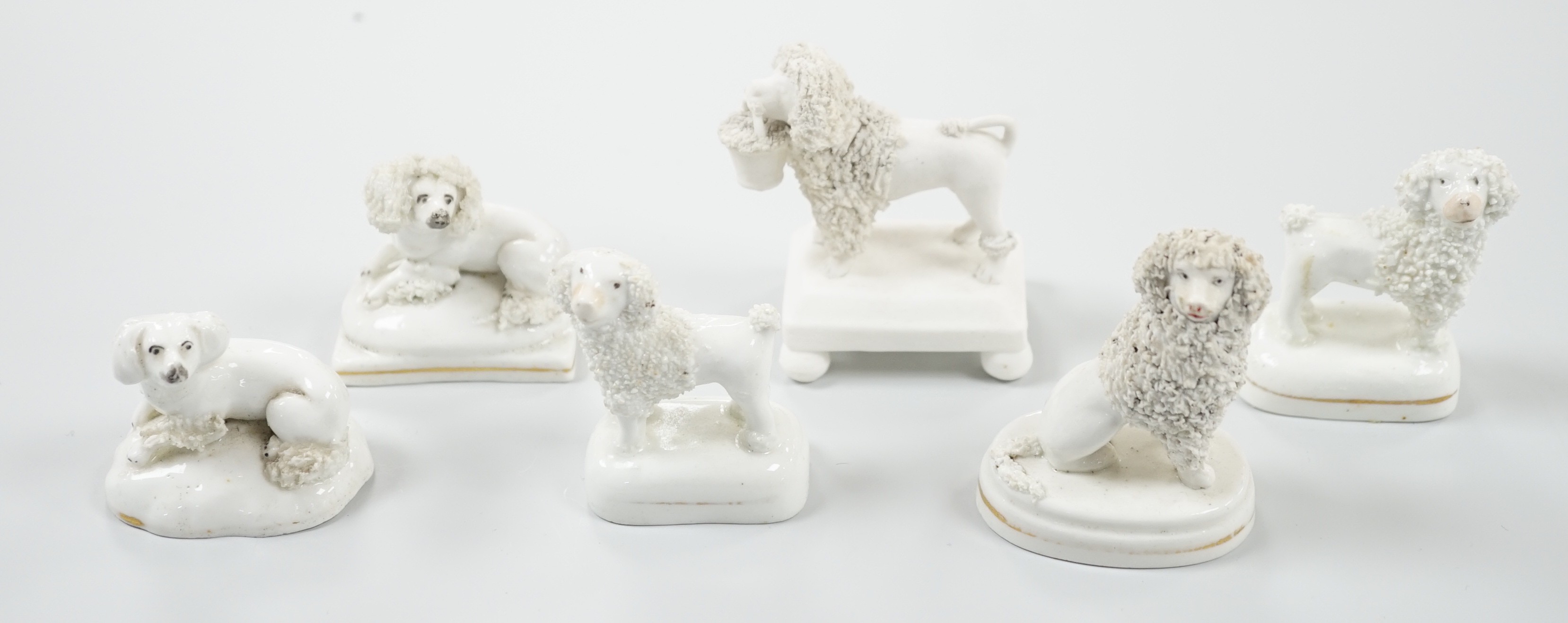 Five small Staffordshire models of poodles, together with a small poodle lying recumbent on an
