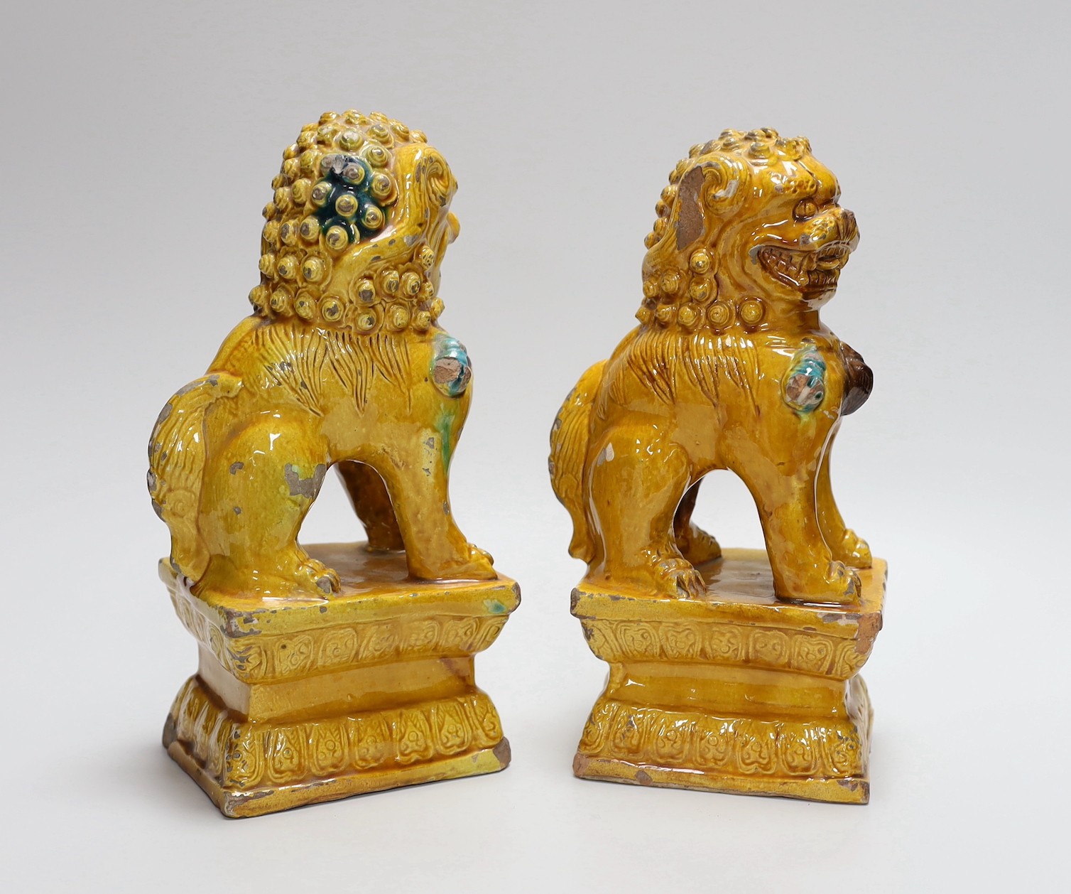 A pair of Chinese ochre glazed Buddhist lion figures, 25cm - Image 2 of 3