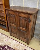 A reproduction oak linenfold moulded two door side cabinet, width 91cm, depth 49cm, height 114cm