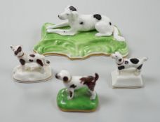 Three toy Staffordshire models of standing terriers; two with brown spots and the other black spots,