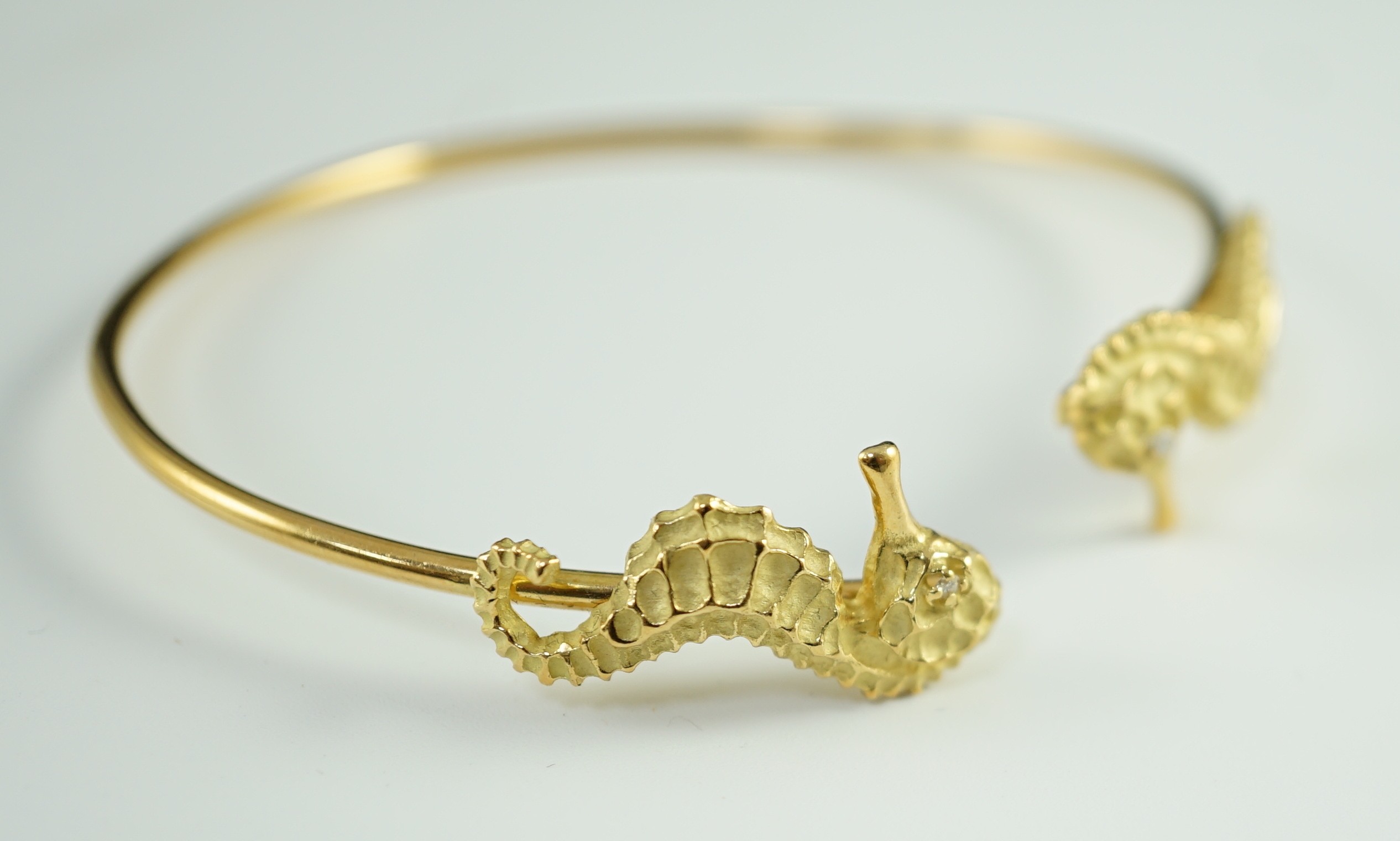 A modern gold and diamond chip set open work bangle, each terminal modelled as a seahorse with - Image 6 of 6