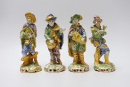 A set of four 19th century faience figures of street peddlers or performers - 18cm tall