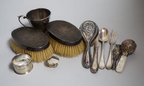 A mixed group of silverware including a pair of silver mounted clothes brushes, two rattles, a