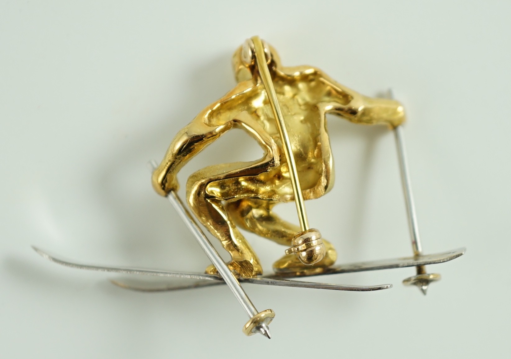 A gold and platinum novelty brooch modelled as a skier, length 39mm, 9.3 grams. - Image 2 of 2