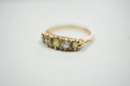 An 18ct, three stone peridot and two stone diamond set half hoop ring. size N, gross weight 2.6