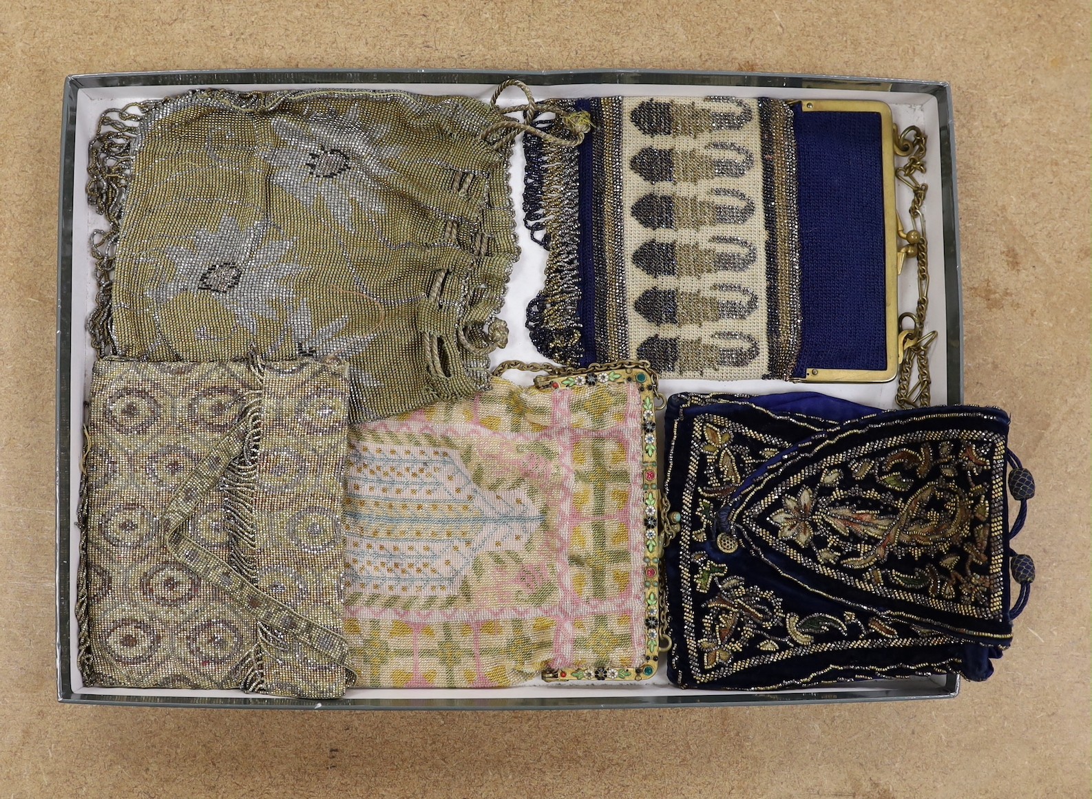 Four late 19th, early 20th century cut steel and finely beaded bags and another similar beaded bag