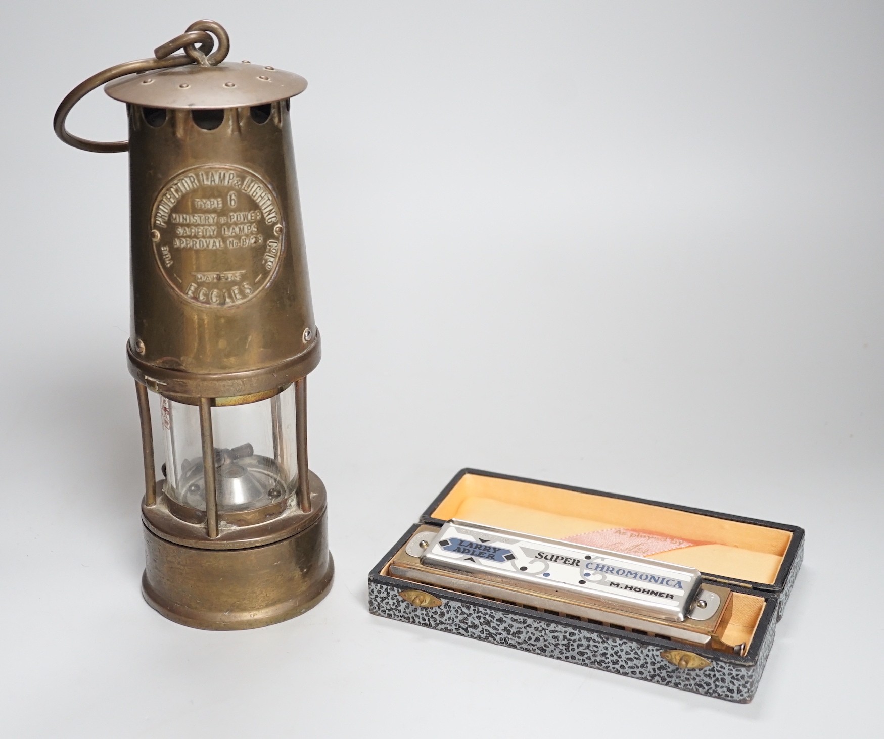 An Eccles miner’s lamp, 25cm high, together with a German harmonica