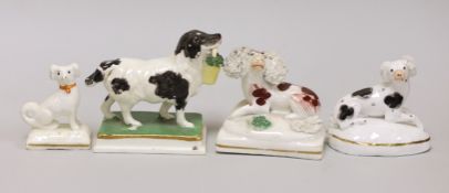 Four small Staffordshire models of spaniels; one seated on rectangular base, two lying