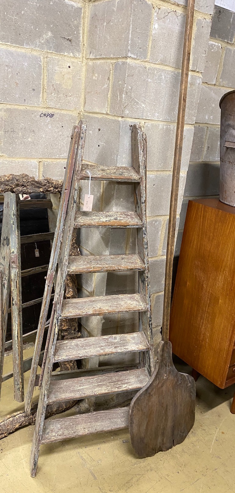 A vintage seven tread wooden step ladder, height 160cm together with a vintage baker's bread paddle