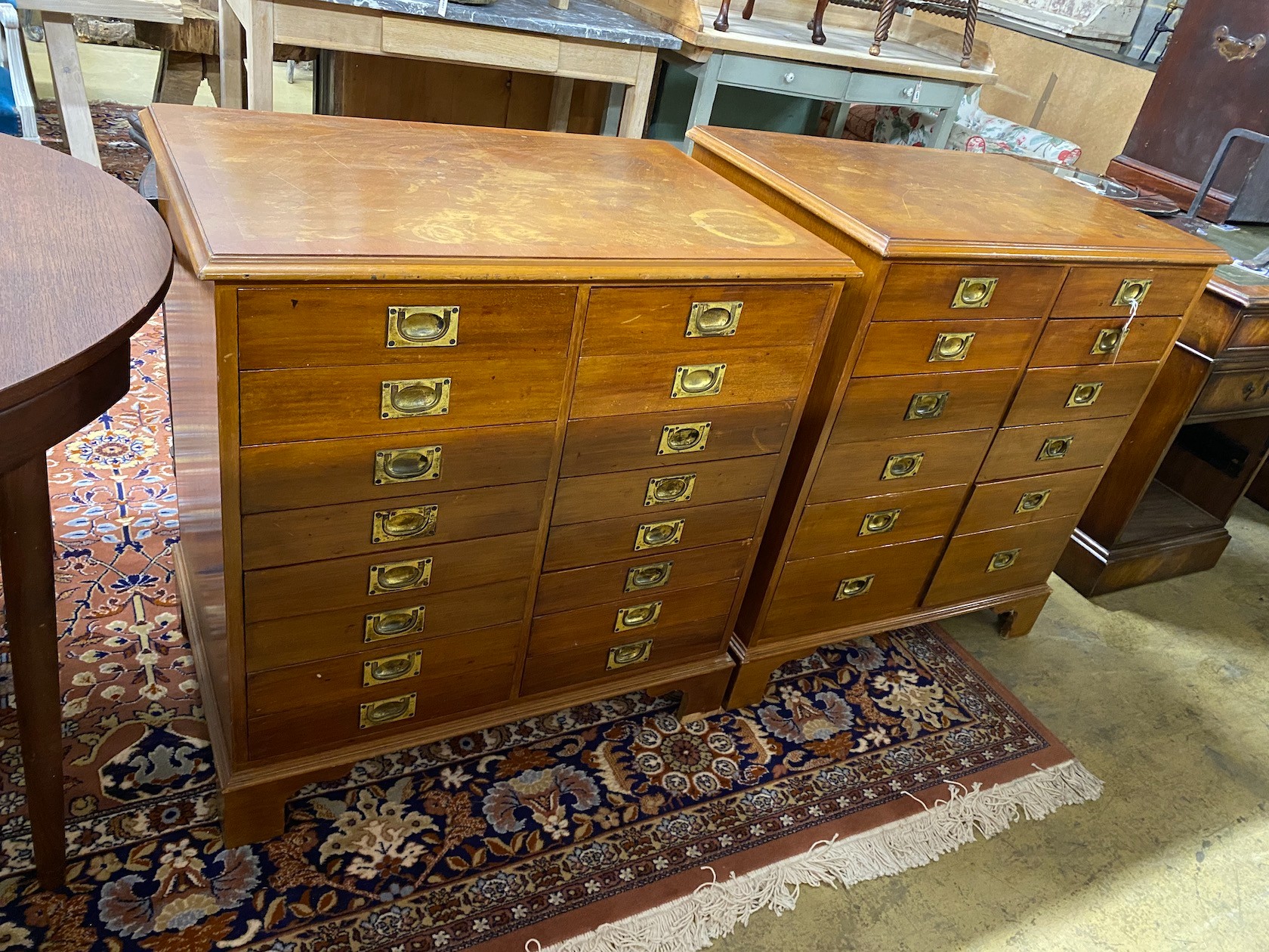 A near pair of mahogany and walnut military style chests of drawers, larger width 82cm, depth