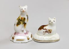 A seated toy Staffordshire cat with tortoiseshell markings, together with a Staffordshire