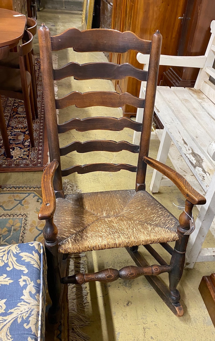 An 18th century Lancashire rush-seated ladder back rocking chair, width 54cm, depth 38cm, height