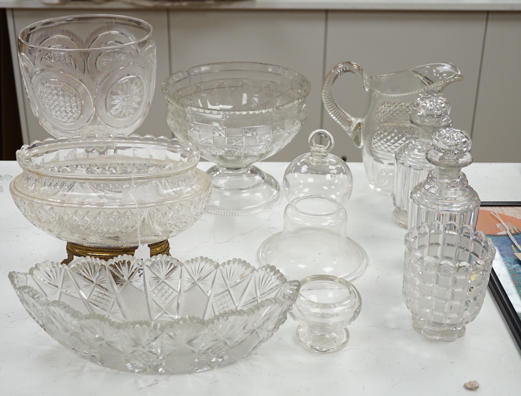 An early 20th century oval cut glass bowl on gilt metal stand, a pair of slice cut decanters and