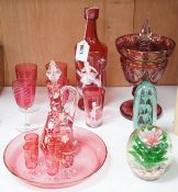 A collection of cranberry glass, a dump paperweight, another and a sweetmeat jar, tallest 28.5 cm
