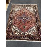 An Heriz red ground rug, 200cms x 148cms