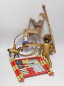 A Victorian carved pine jointed peg doll, jointed wood uni-cyclist toy, two abacuses and an early