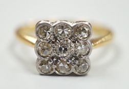 An 18ct and collet set nine stone diamond cluster table ring, size K/L, gross weight 2.6 grams.