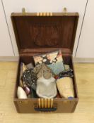 A suitcase containing a collection of late 19th century leather sewing bags and containers, wooden