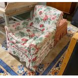 An early 20th century armchair and footstool upholstered in Colefax & Fowler printed fabric