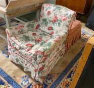 An early 20th century armchair and footstool upholstered in Colefax & Fowler printed fabric