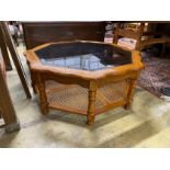 A modern octagonal brass mounted walnut glass top coffee table with caned undertier, diameter 100cm,