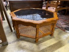 A modern octagonal brass mounted walnut glass top coffee table with caned undertier, diameter 100cm,