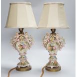 A pair of German porcelain flower encrusted lamps, height 24cm