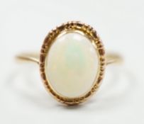 A yellow metal and oval white opal set ring, size Q, gross weight 2 grams.