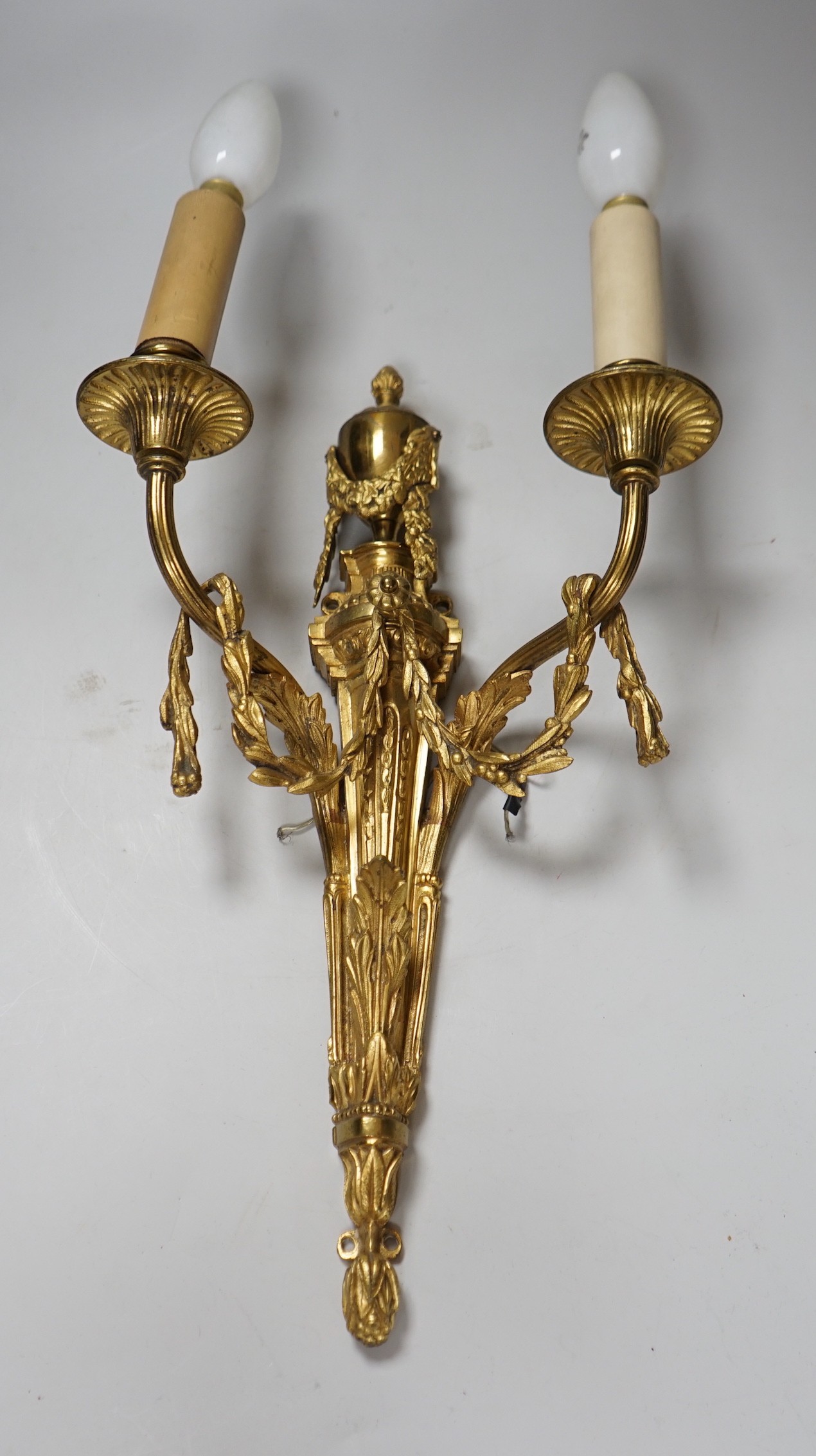 An ornate Louis XVI style gilt metal two branch wall sconce, 48 cm high including bulbs