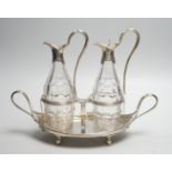 A George III silver navette shaped two handled oil and vinegar stand, with two matching silver