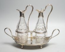 A George III silver navette shaped two handled oil and vinegar stand, with two matching silver
