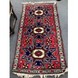 A Caucasian style red ground rug, 180 x 94cm