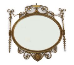 A late Victorian Adam Revival oval wall mirror, with urn, foliate scroll, ribbon and harebell