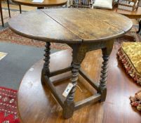 A Carolean style oak drop flap occasional table on spiral turned under frame width 69cm extended,