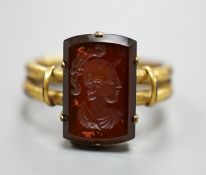 A 19th century yellow metal overlaid and rectangular intaglio chalcedony set ring, the matrix carved